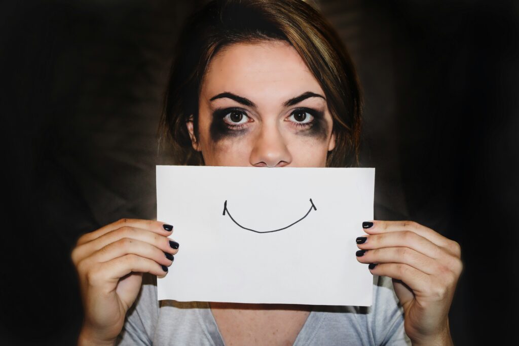 depressed woman hiding her feelings with a fake smile.